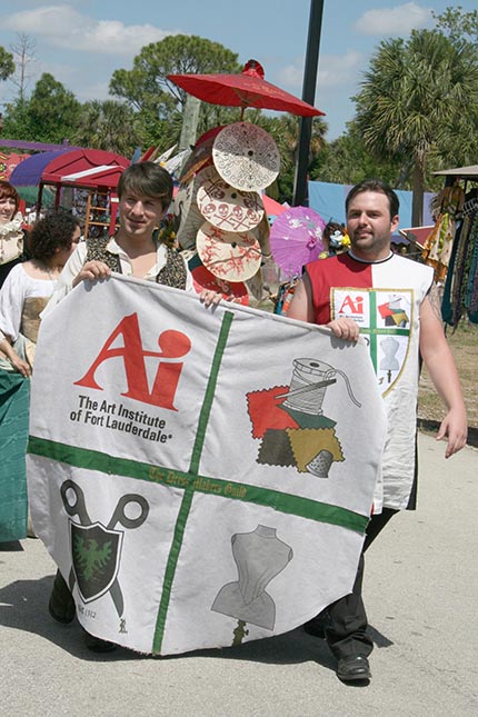 AIFL fashion  students Giovanni Lopez (left) and Tomas Tyma (right)  are carrying the banner of The Art Institute of Fort Lauderdale  at the parade of the Renaissance Festival